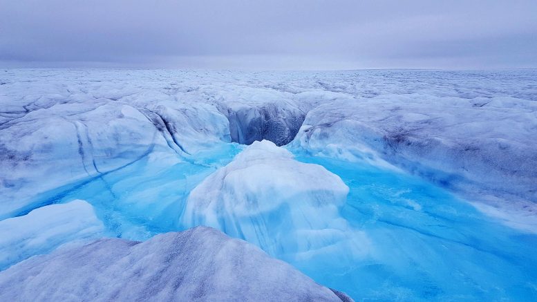 Вода стекает в мулен (отверстие в леднике) и спускается к ложу ледника Сторе, Гренландия