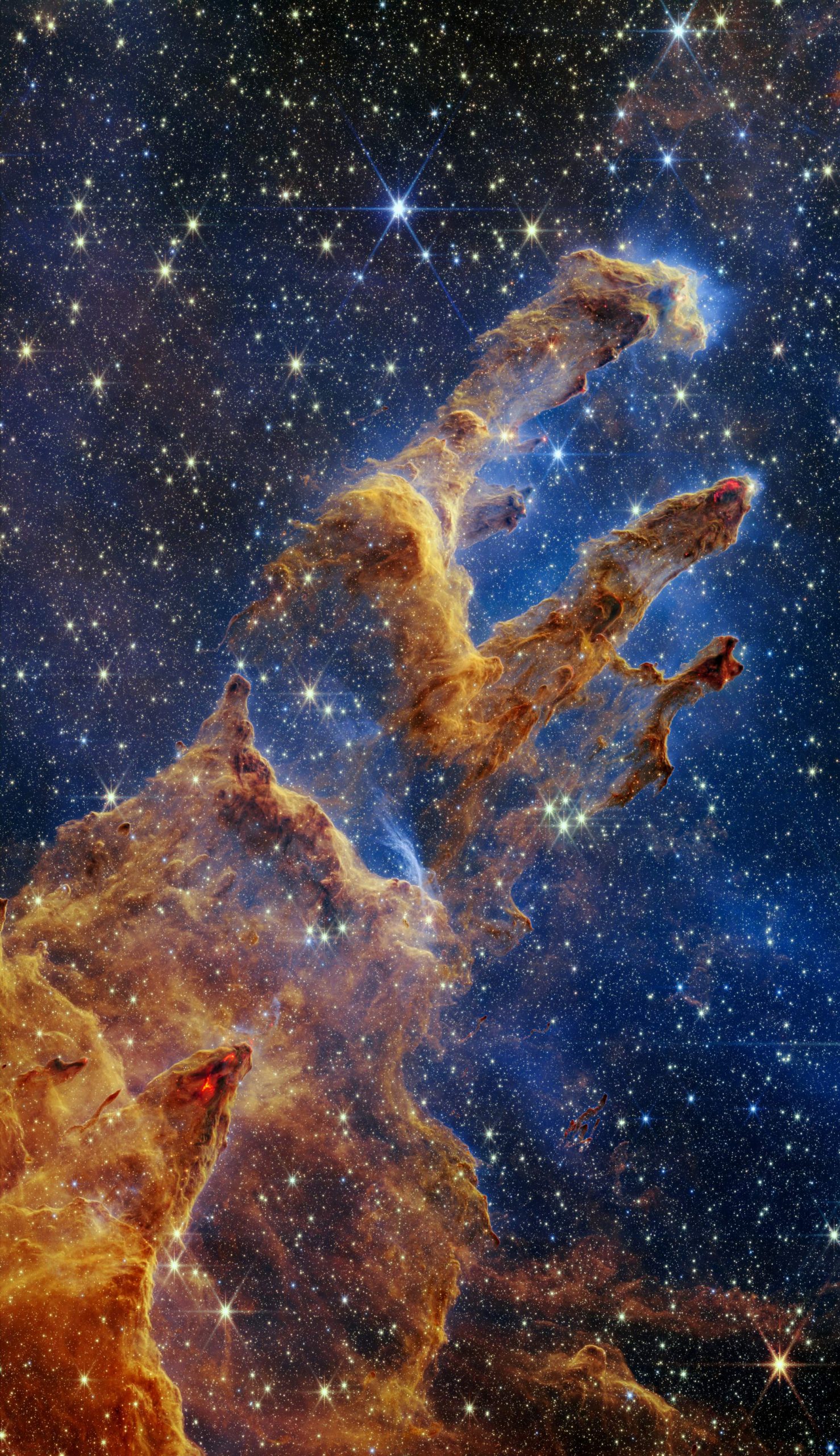 Столпы Творения выделяются в калейдоскопе цветов в ближнем инфракрасном свете космического телескопа Джеймс Уэбб