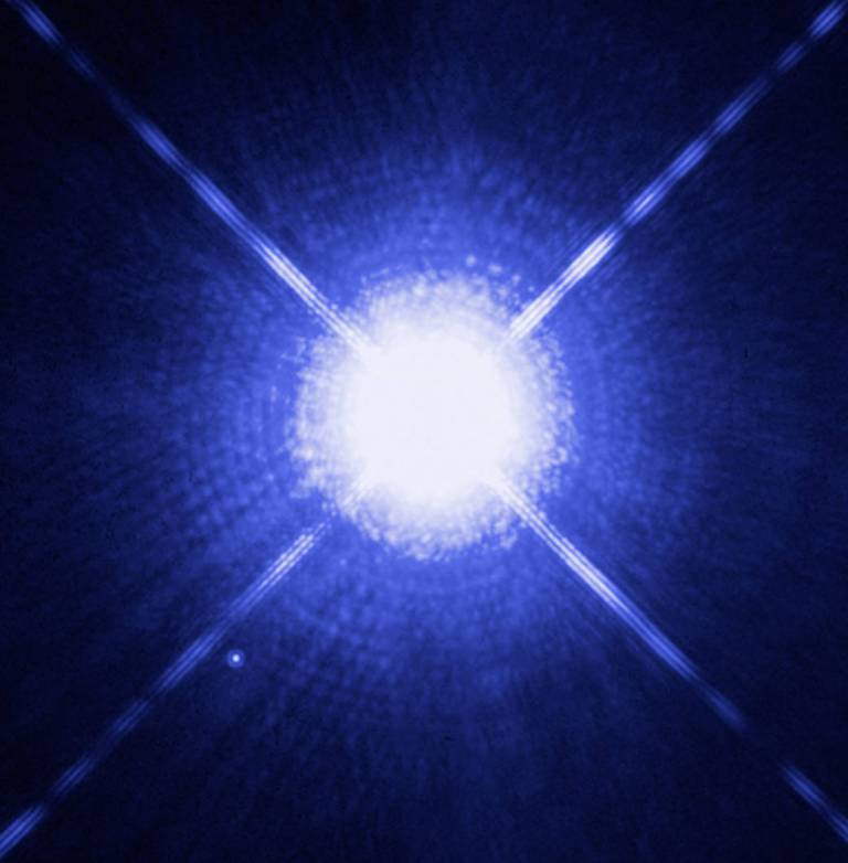 На этом изображении показаны Сириус А и В, более голубая и яркая звезда, чем наше Солнце, и белый карлик соответственно