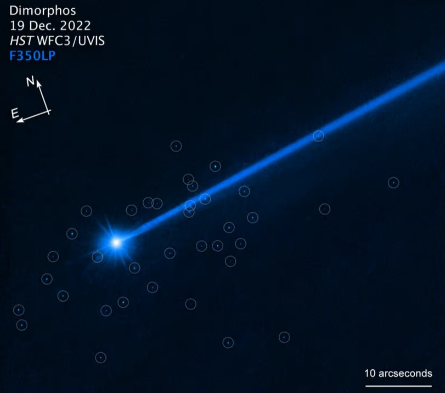 Астероид Диморфос с голубоватым пылевым хвостом, идущим по диагонали вправо вверх