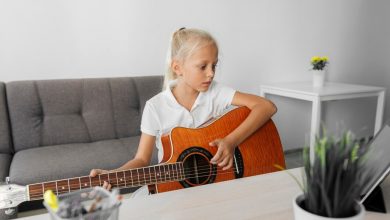девочка играет на гитаре дома